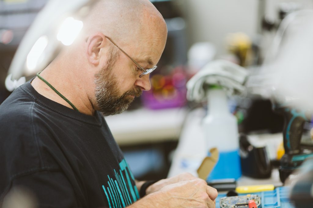 Service Programs. Man repairing equipment.