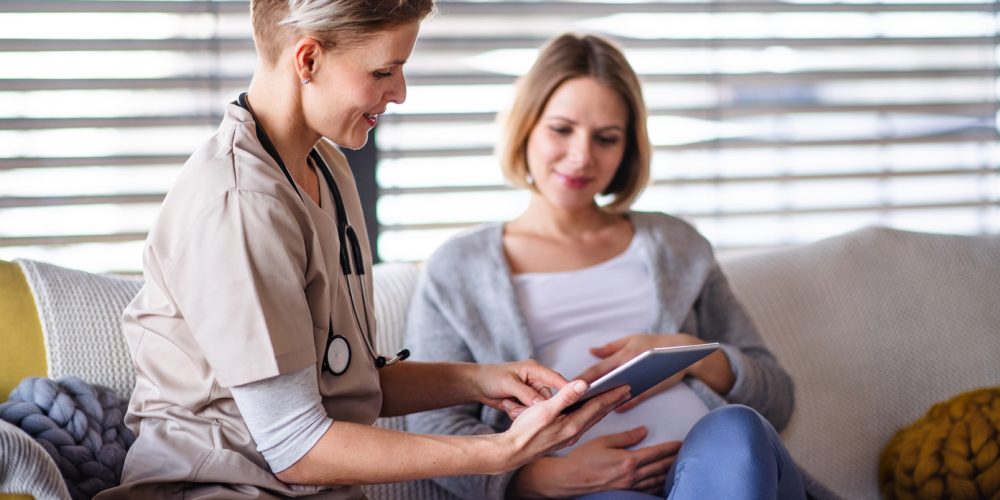 A healthcare worker with tablet talking to pregnant woman. Best Tablets for The Healthcare Industry