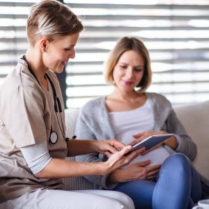 A healthcare worker with tablet talking to pregnant woman. Best Tablets for The Healthcare Industry