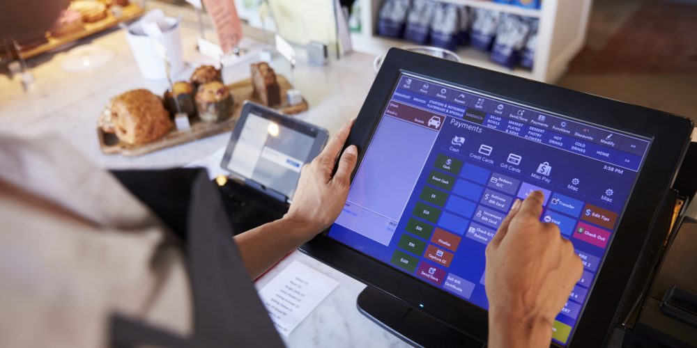 Close Up Of Female Employee using a pos system