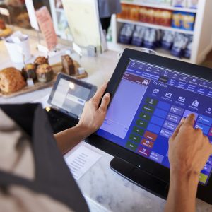 Close Up Of Female Employee using a pos system